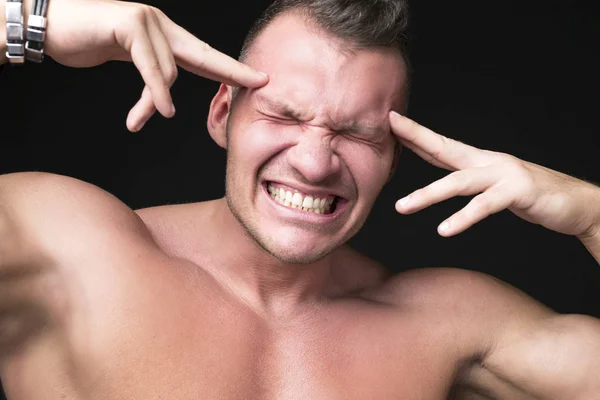 L'uomo ha un mal di testa smorfia. Mantiene le mani sulla testa.Mal di testa e concetto di stress — Foto Stock