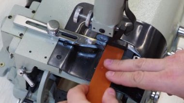 Adam deri yontma makinede çalışıyor. Kenarlarını eğik kesmek için ve özel uygulamalar için çeşitli kalınlıkta deri şeritler bölmek için kullanın. Deri el sanatları kavramı. Erkek el görünümü kapatın