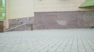 Yakın çekim Kadın bacak ağır armi botlarla yürüme. Moda erkek deri çizmeler yürüyüşte taş sokakta çekim portre.