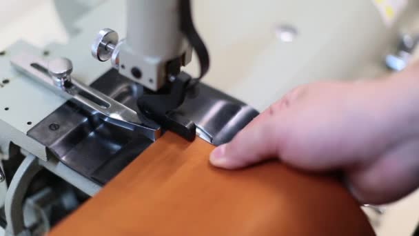 L'homme travaille sur une machine à skiving en cuir. Utilisez-le pour biseauter les bords et diviser les bandes de cuir en différentes épaisseurs pour des applications spéciales. Concept artisanal en cuir. Vue rapprochée des mains masculines — Video
