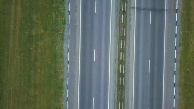 Yaz aylarında park bölgesinin ortasında çeşitli paralel yollar hava görünümünü. Sinematik dron vurdu trafikte yeşil alanları olan yol üzerinde uçan.