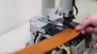 Operatör tuhafiyeler fabrikada makinesinde yontma otomatik deri ayarlıyor. Bölme, hizalama ve deri detaylar, elektrik motorlu tahrik kenar kesim makinesi.