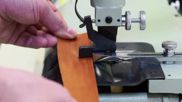 Man using a machine to frame the edge of a leather piece of material. Close up view. Craft and handmade concept — Stock Video