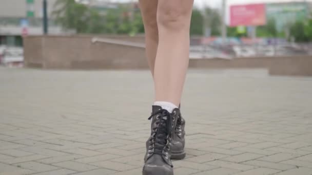Close shot of female legs walking in heavy armi boots. Closeup shooting fashionable female in leather boots walk in street on stone. — Stock Video