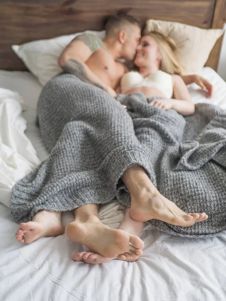 Close up focus on male and female feet. Loving couple is lying on bed. Focus on the feet. Love and relationships concept