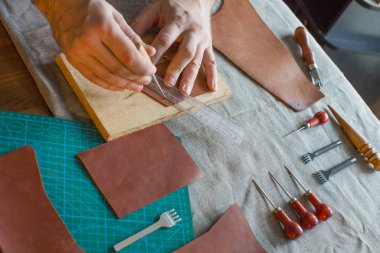 İşlem deri atölyesinde çalışıyor. Adam holding işçiliği aracı ve çalışma. Dikiş bir walet yapmak o. Tanner eski tabakhane içinde.