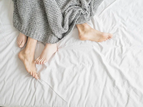 Couple sleeping in bed. Close up view of a feet of a couple. Love and relationships concept