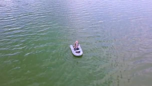 Ψαράς μείνετε σε μια λαστιχένια βάρκα στη λίμνη αυγή το καλοκαίρι. Πρωινή ομίχλη σέρνεται πάνω από το νερό. Σκοποβολή με ύψους πετώντας χαμηλά πάνω από το νερό. — Αρχείο Βίντεο
