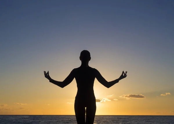 Jeune femme dans une pose de yoga méditant surplombant le magnifique coucher de soleil. Concept d'esprit corps esprit . — Photo