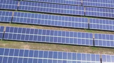 Hava görüntüsü. Güneş enerjisi santralinin üzerinde güneşle uçuyor. Güneş panelleri ve güneş. Hava aracı görüntüsü.