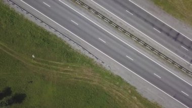 Yolun ortasına park bölgesi yaz aylarında hava görünümünü. Yol trafik ile üzerinde uçan sinematik dron vurdu.