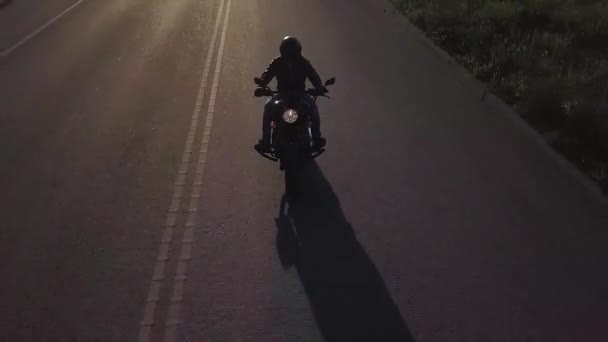 Motociclista conduciendo su moto en la carretera durante el atardecer al atardecer — Vídeo de stock