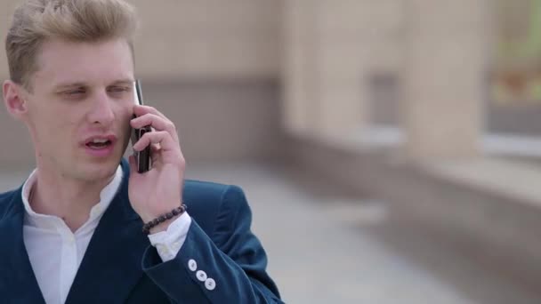 スマート フォン男は夜市の携帯電話で呼び出します。ハンサムな若いビジネス人スマート フォン屋外幸せの身に着けているスーツのジャケットを笑顔で話しています。代の都市の男性プロ — ストック動画