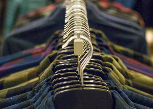 Fechar-se de cabides com camisas diferentes no guarda-roupa. Conceito de venda e compras — Fotografia de Stock