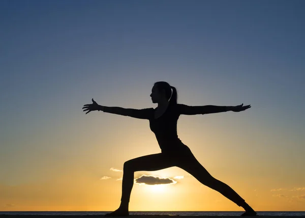 Jeune femme en bonne santé pratiquant le yoga exercice de fitness sur la plage au coucher du soleil. Concept de mode de vie sain. Copier le texte espace . — Photo