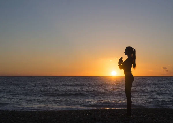 Young healthy woman practicing yoga fitness exercise on the beach at sunset. Healthy lifestyle concept. Copy space text. — Stock Photo, Image