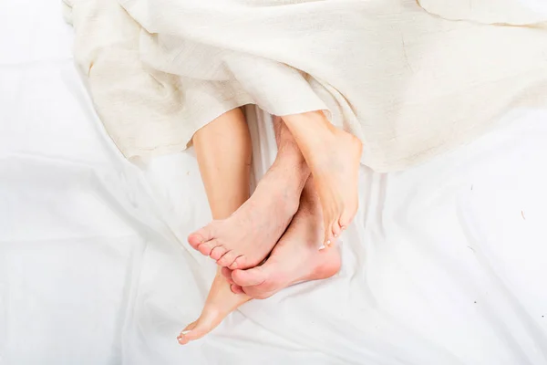 Feet of heterosexual couple during sleep in bed. Love and relationships concept. — Stock Photo, Image