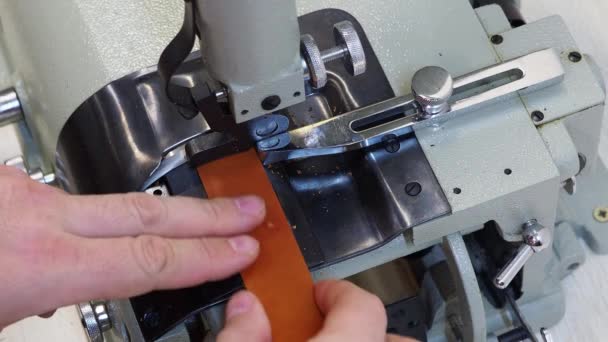 L'opérateur ajuste la machine à skiving automatique en cuir dans une manufacture de mercerie. Fractionnement, alignement et tranchant des détails en cuir, machine électrique à moteur — Video