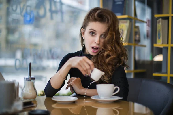 Mujer sorprendida por el derrame de la taza. Mira la cámara. . — Foto de Stock