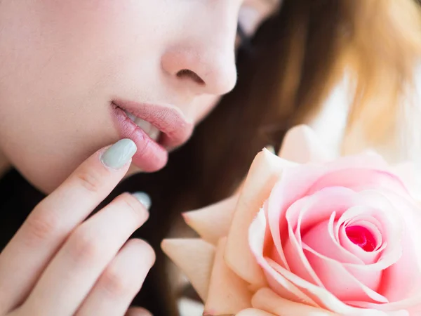 Close-up van een vrouwelijk gezicht met een roos. Gladde schone huid. Gezondheidszorg en skincare concept — Stockfoto