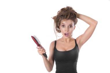 Beyaz bir arka plan üzerinde elinde bir saç fırçası ile hayal kırıklığına kız. Saç sağlık kavramı