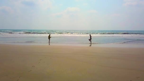 Två medelålders personer som spelar badminton på stranden vid solnedgången. kärlek, hälsosamt liv och relationer koncept — Stockvideo