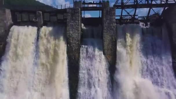Vue aérienne. Tournage d'une cascade et d'un vieux barrage. Paysage estival. La caméra se déplace du barrage vers l'arrière et vers le haut révélant tout le terrain . — Video