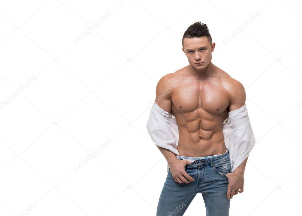 Man in blue jeans and white shirt touching his perfect abs isolated on white.