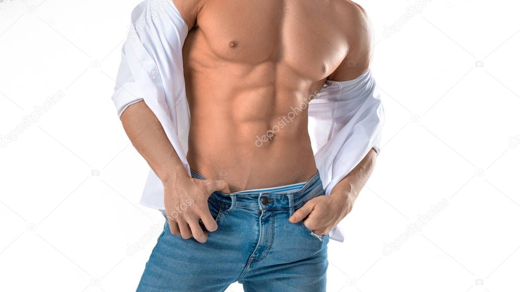Male torso with perfect abs. Man in blue jeans and white shirt isolated on white.