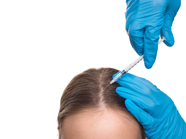 Beyaz arka plan üzerinde enjeksiyon alan saç dökülmesi sorunu olan bir doktor ve kadının elleri — Stok fotoğraf