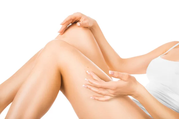 Wanita menyentuh kakinya dengan kulit bersinar yang sempurna. Konsep perawatan kulit. Terisolasi di atas putih . — Stok Foto