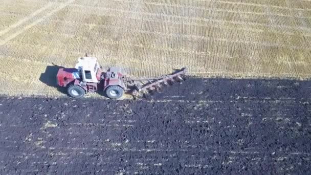 Luchtfoto camera rechtstreeks neerkijkt op anding met een trekker het planten van aardappelen in een veld. — Stockvideo