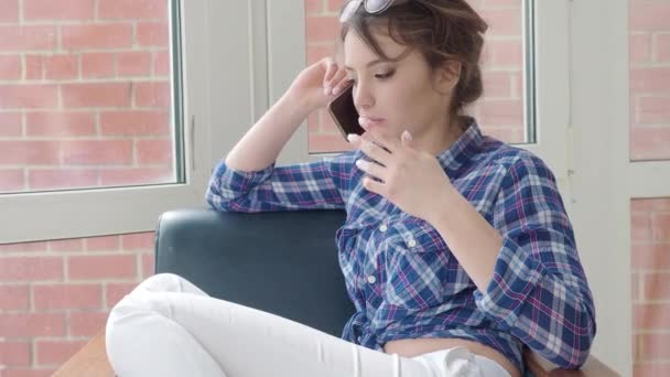 Glädjande ung kvinna talar på mobiltelefon hemma — Stockvideo