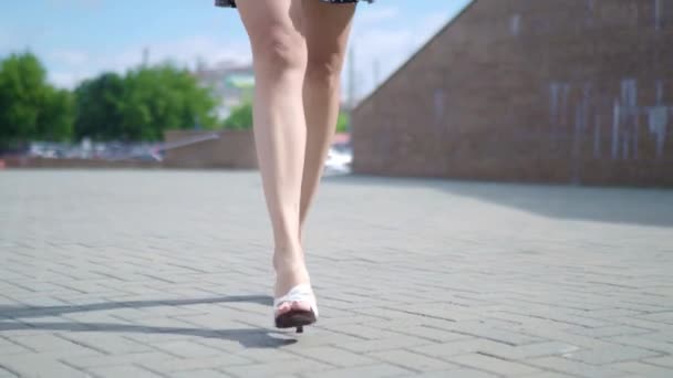 Szexi nő lábak magas sarkú cipő, séta a város városi utcán. Steadicamnél stabilizált lövés, a magas sarkú cipő, női lábak közelről.