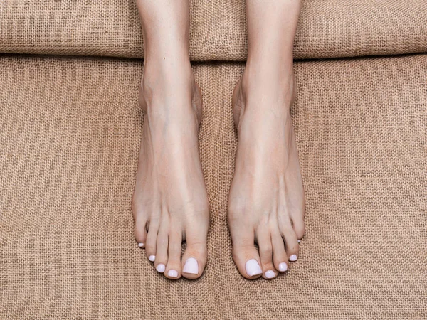 スパサロンのキャンバスに女性の足のビウをクローズアップ。マッサージとフィートケアの概念. — ストック写真