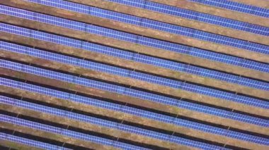 Hava görüntüsü. Güneş enerjisi santralinin üzerinde güneşle uçuyor. Güneş panelleri ve güneş. Hava aracı görüntüsü.