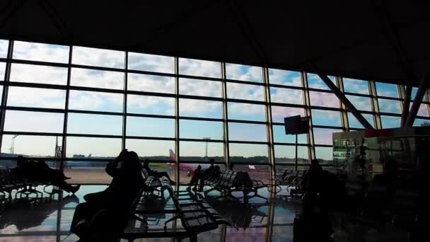 Siluety lidí v letištním terminálu. HNOU, o jejich letu a o podnikání. — Stock video