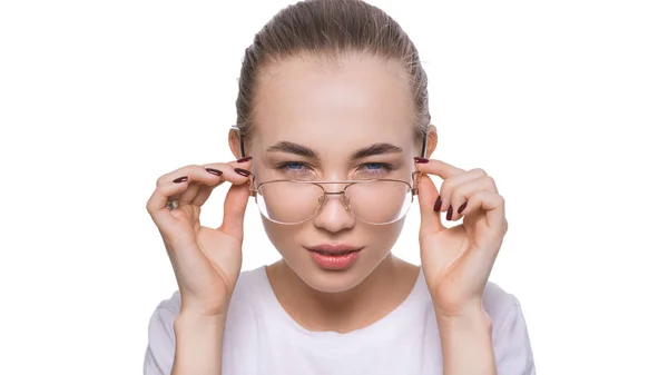 Mujer joven con gafas mirando a la cámara con duda y desconfianza. Problema con los ojos, concepto de atención médica — Foto de Stock