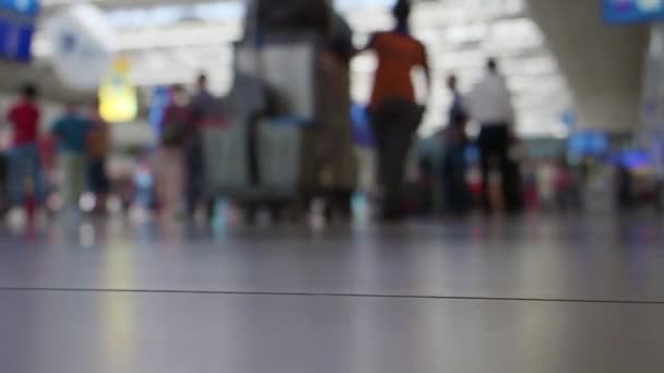 Imágenes borrosas de pasajeros caminando al mostrador de facturación en la terminal del aeropuerto internacional. Vídeo FHD con efecto desenfocado . — Vídeos de Stock