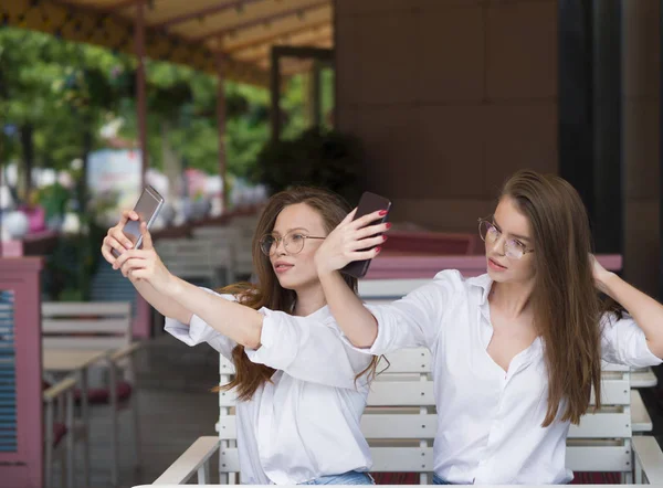 Két nő, hogy a selfie ülve egy nyári kávézóban. Találkozó és barátság. A közösségi hálózatok koncepciója. — Stock Fotó