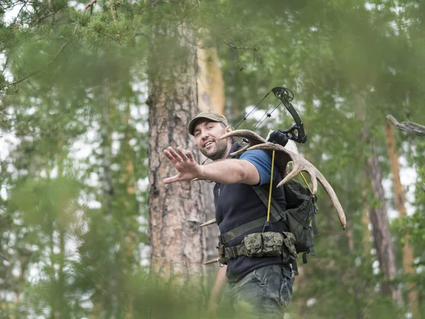 Вид охотника в лесу несет рога лося на спине — стоковое фото