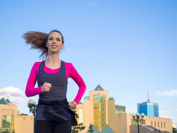 Una mujer corriendo por las calles de un pueblo. Fitness concepto de estilo de vida saludable . — Foto de Stock