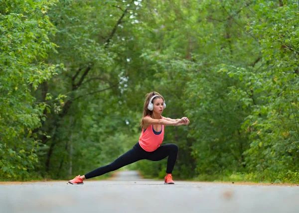 Kobieta rozciągnąć mięśnie w parku przed joggingu. Sportowe ćwiczenia na zewnątrz. — Zdjęcie stockowe