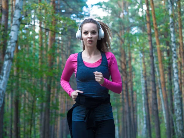 Mujer corriendo en el bosque arbolado. Fitness concepto de estilo de vida saludable . — Foto de Stock