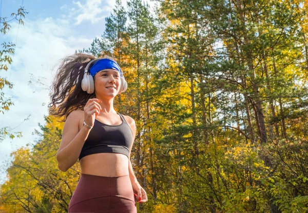 Woman jogging outdoor. Close up side portrait. Autumn