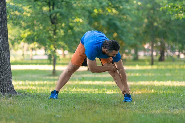 Homme échauffement avant le jogging en plein air en été . — Photo