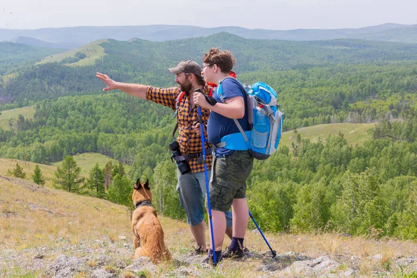 Père, fils et leur chien voyagent dans la nature, randonnées en montagne . — Photo