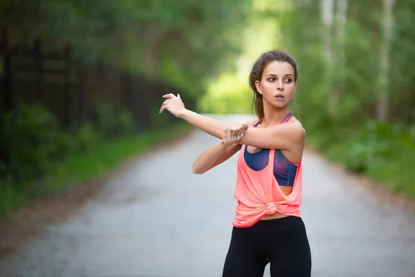 Concepto de deporte y estilo de vida saludable: músculos de calentamiento de la mujer antes del entrenamiento. Mirando al lado . — Foto de Stock