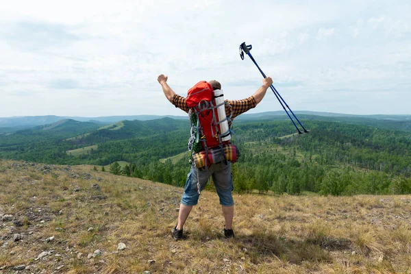 Randonneur d'âge moyen routard homme cultivant les mains avec des bâtons de trekking pendant la marche d'acclimatation en haute altitude . — Photo
