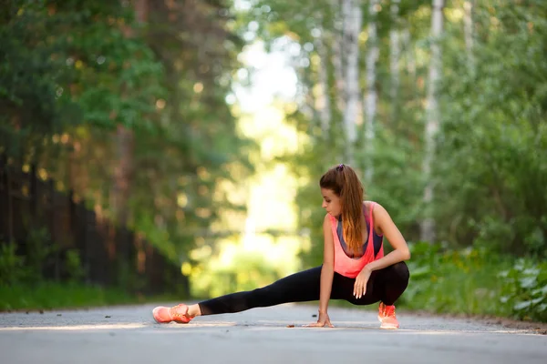 Mujer calentando músculos antes de trotar. Concepto de deporte y estilo de vida saludable . — Foto de Stock